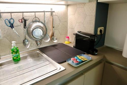 Una encimera de cocina con fregadero y microondas. en A due passi dal Centro & Parcheggio Gratuito, en Turín