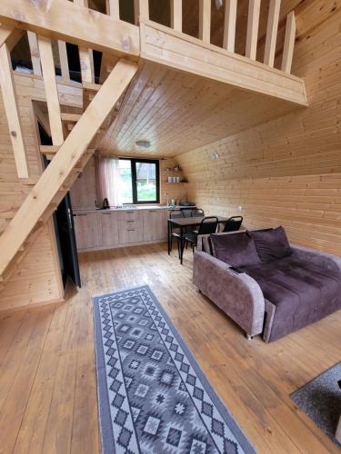 a living room with a couch and a table at Pine Chalet Kazbegi in Stepantsminda