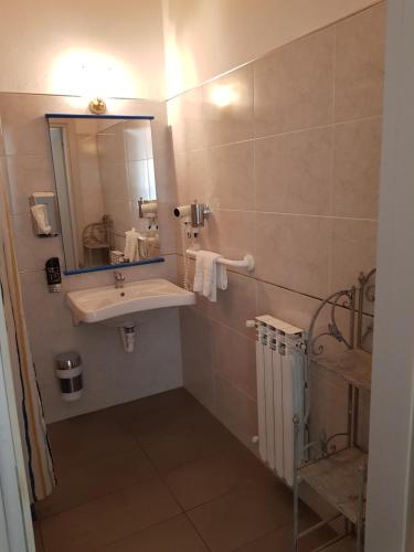 ein Bad mit einem Waschbecken und einem Spiegel in der Unterkunft Hotel Villa Pagoda in Sirmione