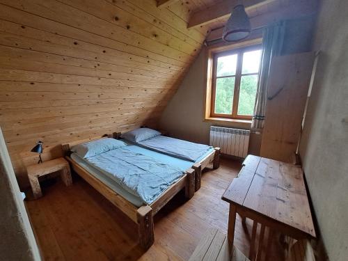 1 dormitorio con 1 cama en una habitación de madera en Lipie12a - pokoje en Lipie