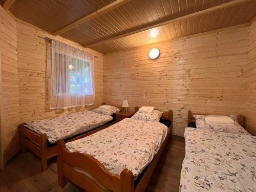a room with three beds in a log cabin at Domki u Pieszczocha in Bukowiec