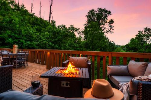 a patio with a fire pit on a deck at Mountainside - New Luxury Cabin-Fire Table-Hot Tub-3 Pools-PS5-Bears in Gatlinburg