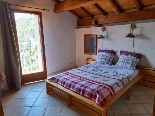 a bedroom with a bed and a large window at Stella Alpina in Rimplas