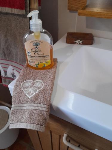 - une bouteille de savon assise sur une serviette à côté d'un lavabo dans l'établissement Stella Alpina, à Rimplas