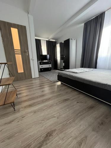 a bedroom with a bed and a wooden floor at Casa Dorina in Techirghiol