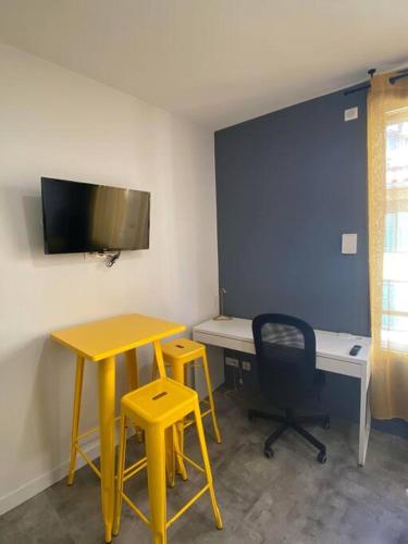 Cette chambre comprend un bureau, une table et une chaise. dans l'établissement Le Dolaizon, appartement avec ascenseur, au Puy-en-Velay