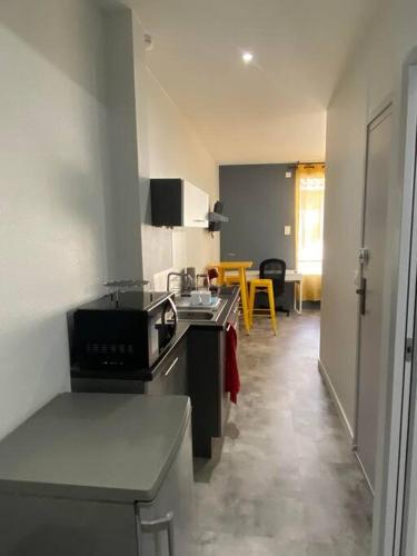 a kitchen with a sink and a stove top oven at Le Dolaizon, appartement avec ascenseur in Le Puy en Velay