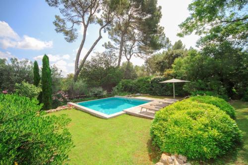 una piscina en un jardín con arbustos y árboles en Villa CONTEMPORAINE Piscine Montpellier en Montpellier