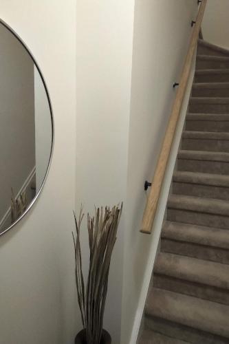 a staircase in a house with a mirror and a plant at GGP Boutique Townhome in Vaughan