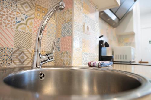 - un évier en acier inoxydable dans une cuisine revêtue de carrelage dans l'établissement Apartamentos Lurralde, à Zarautz