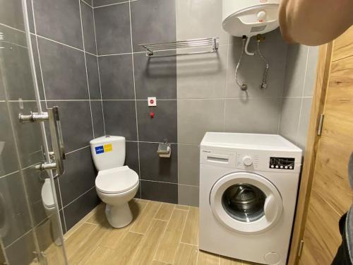 a bathroom with a toilet and a washing machine at КАСКАДАС Луксозни нови студия in Sunny Beach