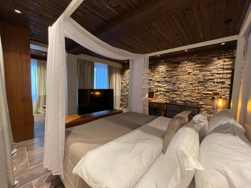 a bedroom with a white bed with a stone wall at Vlasinsko jezero VILA BEST in Surdulica