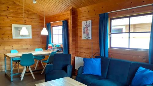 comedor con sillas azules y mesa en Lupine Lodge en Gramsbergen