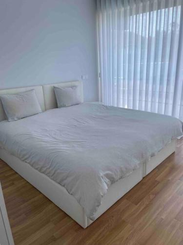 a white bed in a room with a window at Villa - Âncora - 300 mètres de l’océan in Vila Praia de Âncora