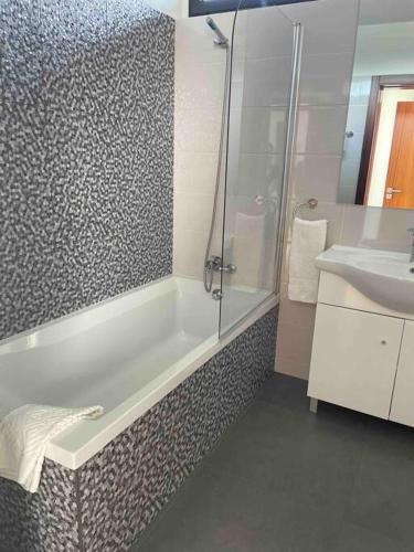 a bathroom with a shower and a tub and a sink at Villa - Âncora - 300 mètres de l’océan in Vila Praia de Âncora