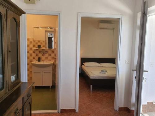 um quarto com uma cama, um lavatório e um espelho em Apartmani Barada em Seget Vranjica
