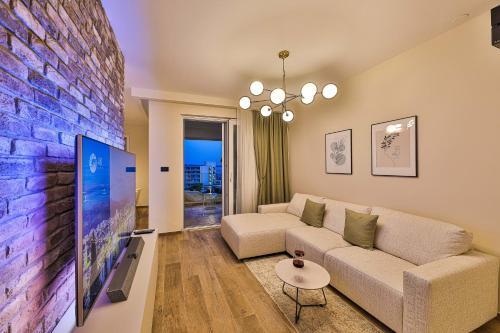 OLIVETUM luxury apartment في سبليت: غرفة معيشة مع أريكة وتلفزيون كبير