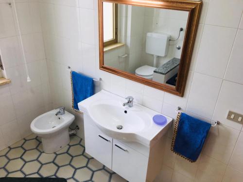 a bathroom with a sink and a mirror and a toilet at Villa Ida in Capo Rizzuto