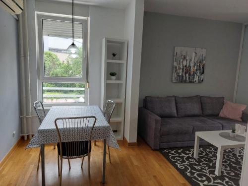 a living room with a table and a couch at Apartman AMORE Belvil in Novi Beograd
