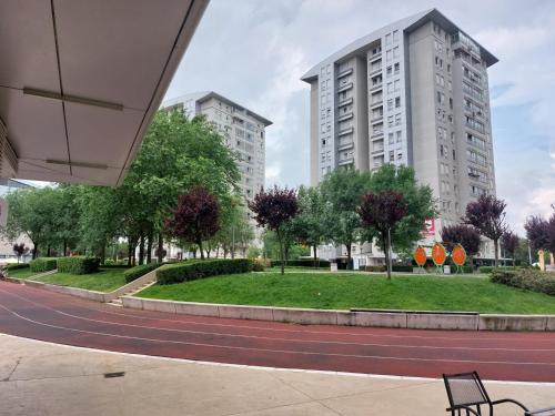 a park in front of two tall buildings at Apartman AMORE Belvil in Novi Beograd