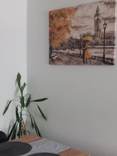 a painting of a woman with an umbrella on a wall at Apartmani Djuric Center in Subotica