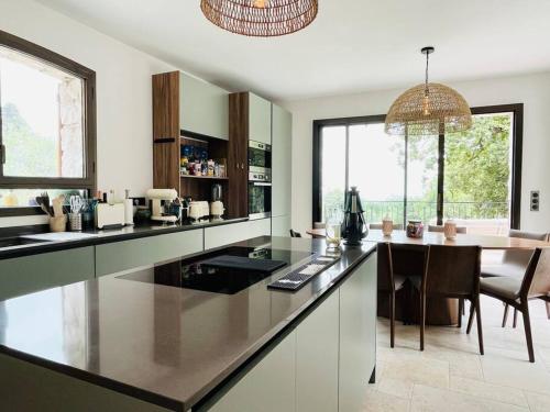 une cuisine avec un grand comptoir et une salle à manger dans l'établissement Paisible et Spacieuse Villa avec 4 suites indépendantes, à La Gaude