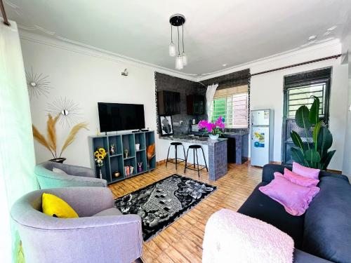 ein Wohnzimmer mit 2 Sofas und einem TV in der Unterkunft Apartment unit-White house with Two bedrooms in Bulindo