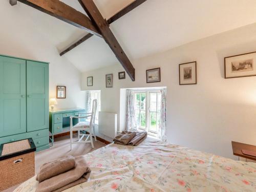 a bedroom with a large bed and a desk at Stable Cottage - 26032 in Wark