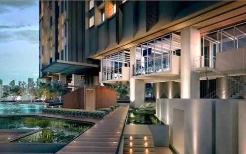 an exterior view of a building with a pond at Bunga Suite at Lucentia BBCC in Kuala Lumpur