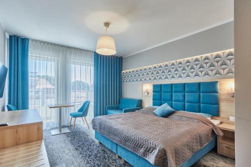 a bedroom with a blue bed and a desk at Apartamenty Świnoujście - Wyspiańskiego 34e in Świnoujście