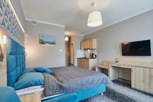a bedroom with a blue bed and a desk at Apartamenty Świnoujście - Wyspiańskiego 34e in Świnoujście