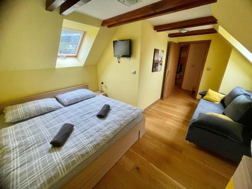 - une chambre avec un grand lit et un canapé dans l'établissement APARTMÁN MEZONET DONOVALY Plesnivec, à Donovaly