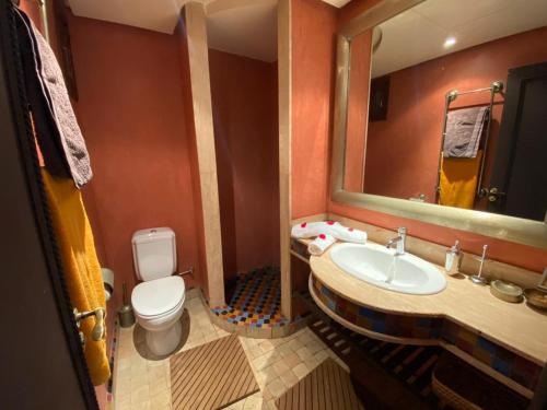 a bathroom with a sink and a toilet and a mirror at Villa Agdal in Marrakech