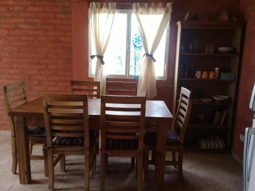 a dining room table with chairs and a window at Casa Munay in Uspallata