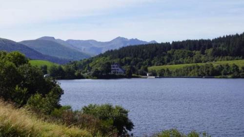 a large lake with a house in the middle at Tulipe, appartement 5 personnes, entre Sancy et Volcans d'Auvergne in Orcival