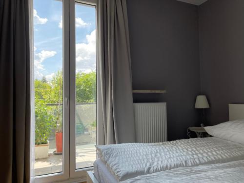 um quarto com uma cama e uma grande janela em Apartamenty Warszawa Centrum Włodarzewska 30 em Varsóvia