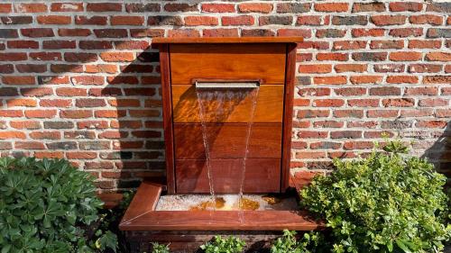 a water fountain in front of a brick wall at Bourgogne en Grez in Grez-Doiceau