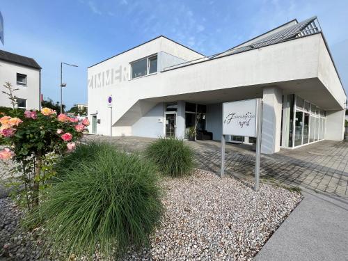 a white building with a sign in front of it at Frühstückspension Ingrid in Neutal