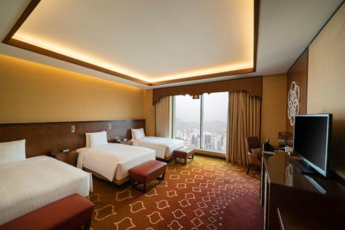 a hotel room with two beds and a flat screen tv at Jabal Omar Marriott Hotel Makkah in Makkah