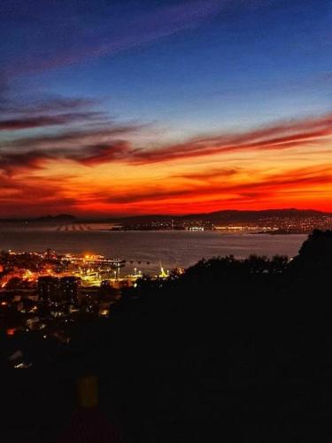 una vista de la ciudad por la noche con una puesta de sol en Piso con preciosas vistas de vigo, en Vigo