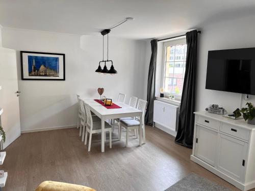 a living room with a white table and a tv at Ferienwohnung Baustraße in Hameln