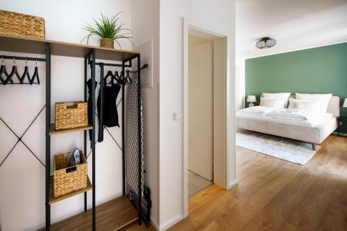 a living room with a bed in the background and a closet at STAYTONA - Parkpl. - Balkon - WLAN - Netflix - WFH in Taunusstein