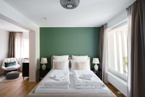 a bedroom with a bed with a green wall at STAYTONA - Parkpl. - Balkon - WLAN - Netflix - WFH in Taunusstein