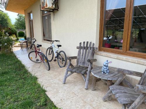 um banco e duas bicicletas estacionadas ao lado de uma casa em Guest House Golden Flake 4km from Bolata beach em Bŭlgarevo