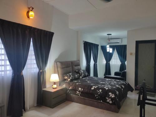 1 dormitorio con 1 cama con cortinas azules y silla en Grey Fantasy Homes#Sunway Water Theme Park en Ipoh