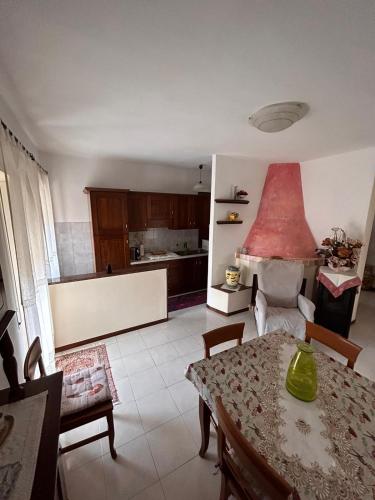 a living room with a table and a kitchen at Casa vacanze in Berchidda