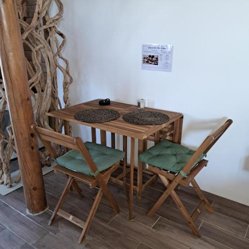 a wooden table with two chairs and a table with a table at Chambre d'hôtes des Loyes in Jaillans