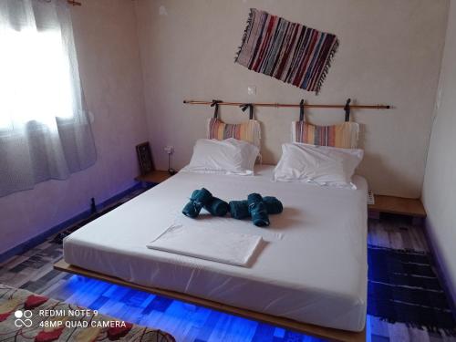 un osito de peluche sentado en una cama en un dormitorio en zikos house, en Monemvasia