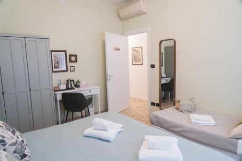 a bedroom with two beds and a desk and a mirror at Arena Rooms in Verona
