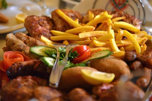 a plate of food with french fries and meat at ĆAKA Luxury Rooms & Restaurant in Ćuprija